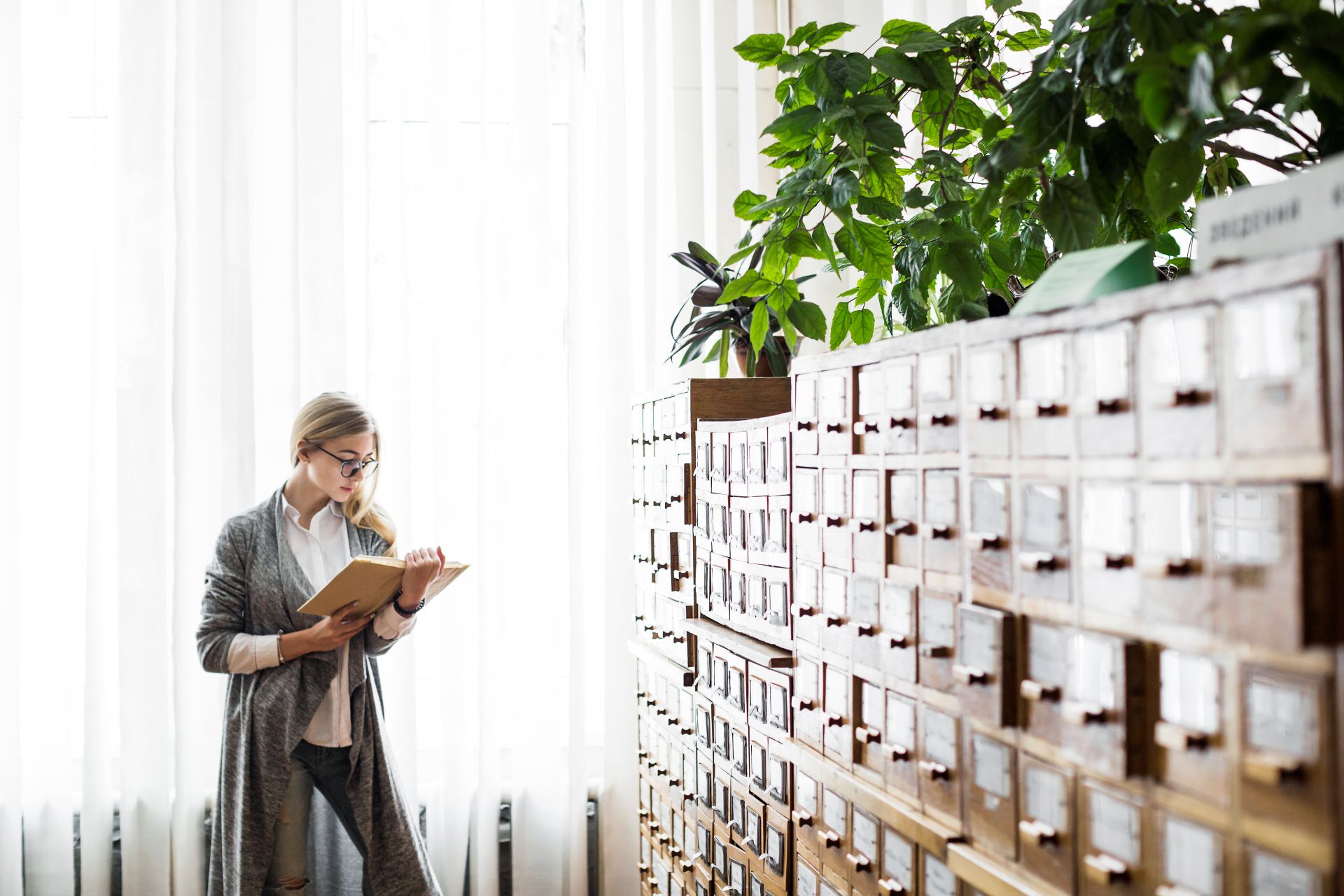 woman-reading-book-near-window